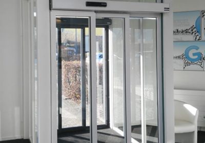 Double porte automatique coulissante moderne dans l'entrée d'un bureau à Bruxelles